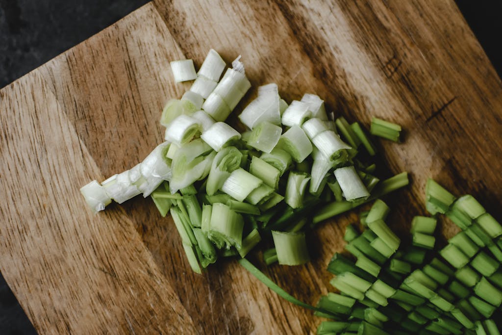 Close-up of chopped green onions on a wooden board, perfect for food preparation imagery.